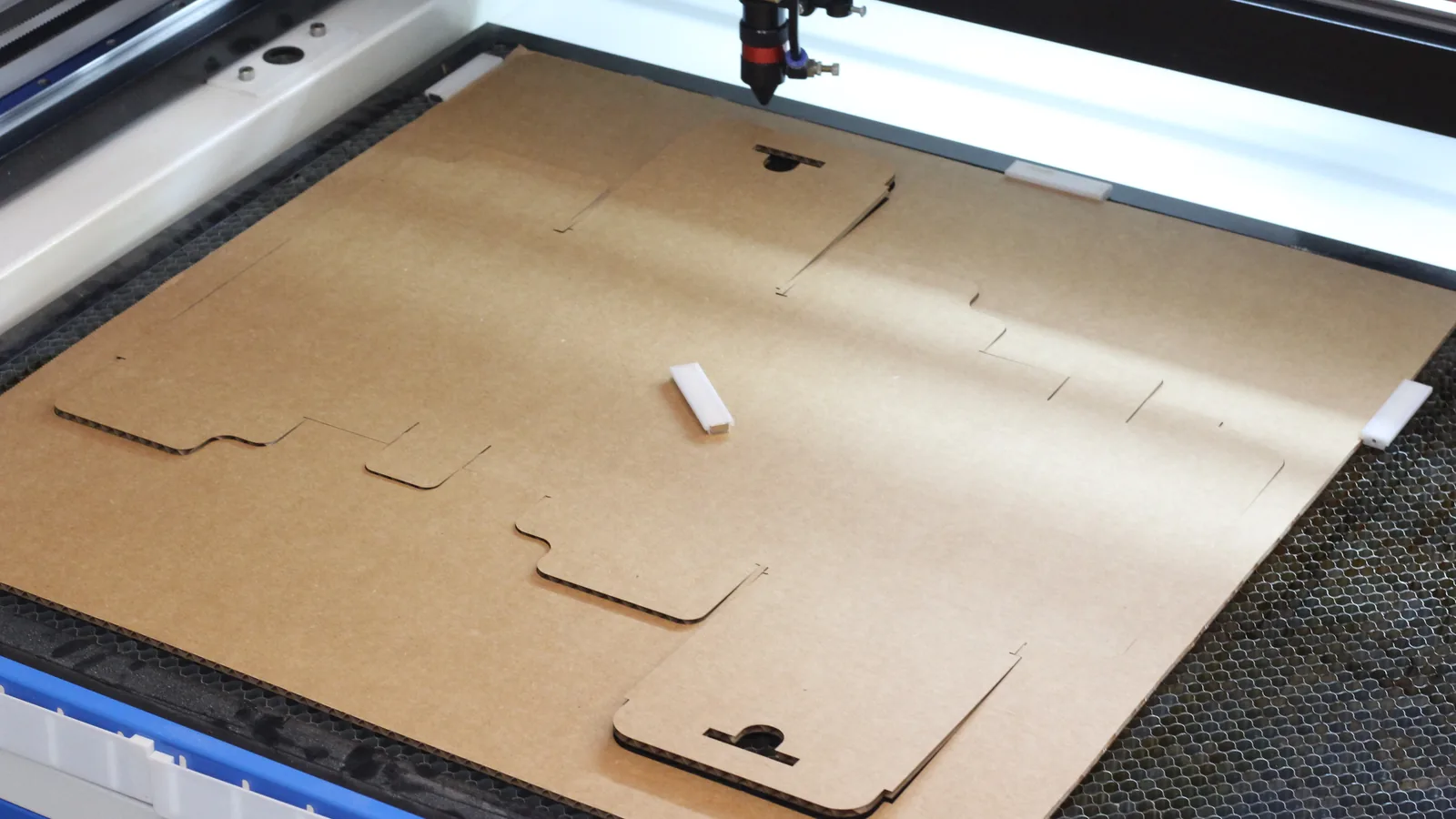Laser cut tuck-top cardboard box template on a CO2 laser bed